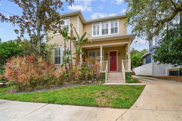 view of front of house featuring covered porch and fence