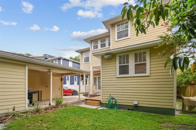 rear view of house featuring a patio, a lawn, and fence