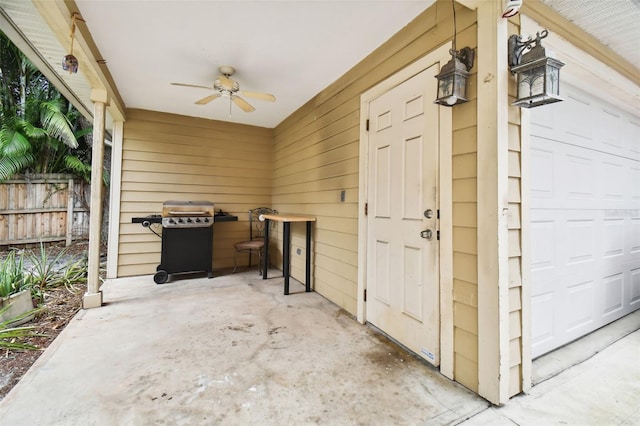 exterior space featuring a garage, ceiling fan, area for grilling, and fence