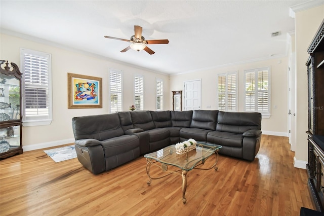 living area featuring crown molding, baseboards, ceiling fan, and wood finished floors