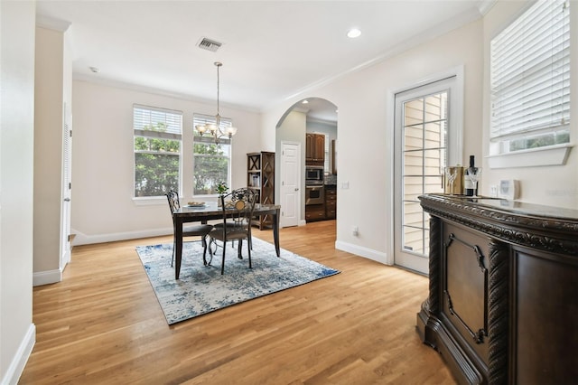 dining space featuring light wood-style floors, visible vents, a notable chandelier, and ornamental molding