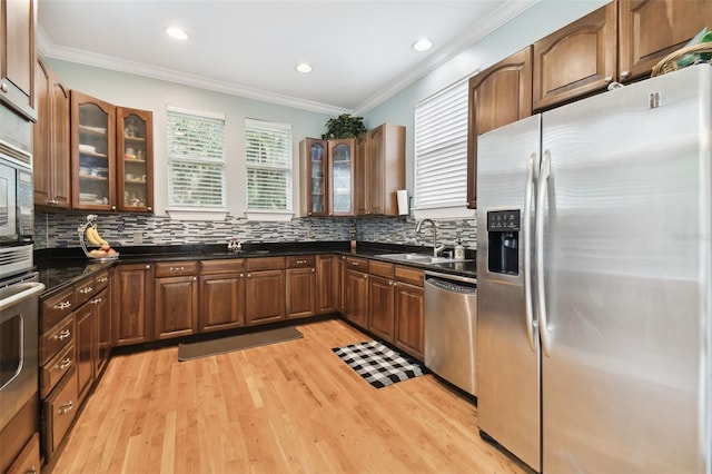 kitchen featuring dark countertops, decorative backsplash, stainless steel appliances, and a sink