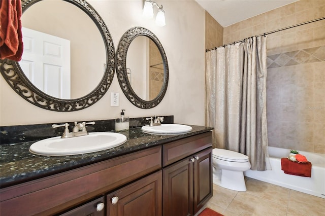 full bathroom with double vanity, tile patterned flooring, a sink, and toilet