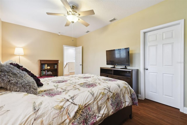 bedroom featuring visible vents, ceiling fan, a textured ceiling, and wood finished floors