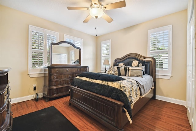 bedroom featuring ceiling fan, multiple windows, baseboards, and wood finished floors