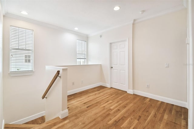 spare room with light wood-style floors, baseboards, crown molding, and recessed lighting