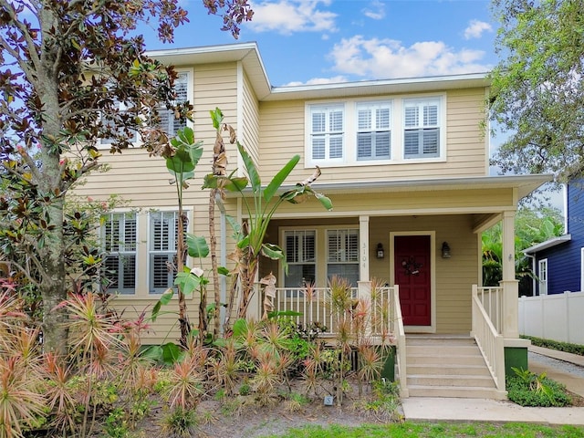 view of front of house with a porch and fence