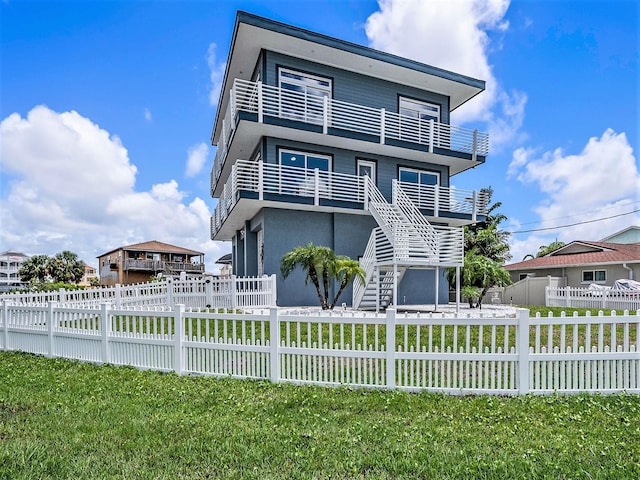 view of front facade with a front yard and a balcony