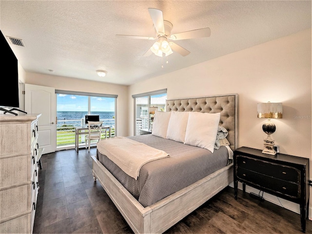 bedroom with ceiling fan, access to outside, and a textured ceiling