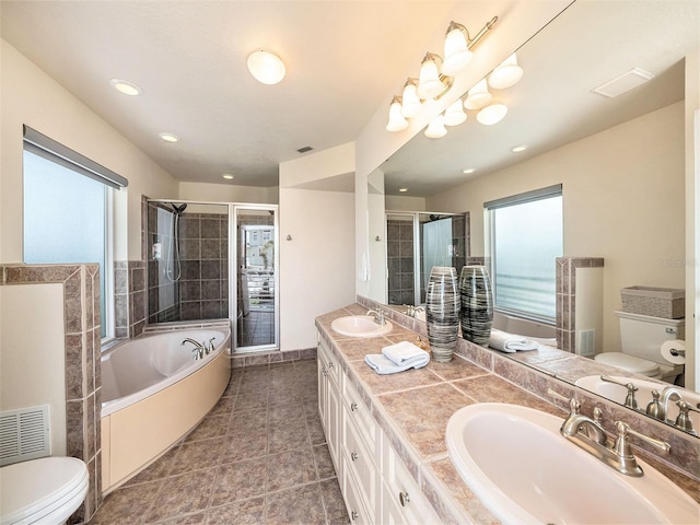 full bathroom with a healthy amount of sunlight, separate shower and tub, vanity, and toilet