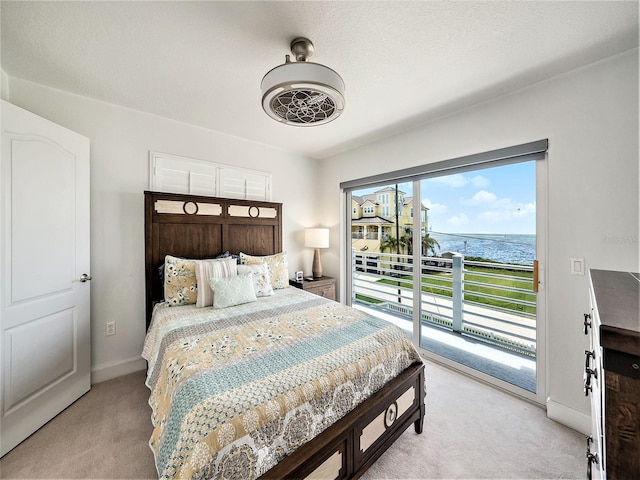 carpeted bedroom with a water view and access to exterior