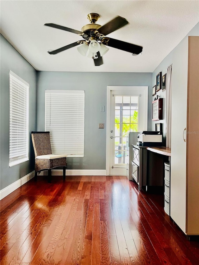 unfurnished room with ceiling fan, dark wood-type flooring, and a textured ceiling