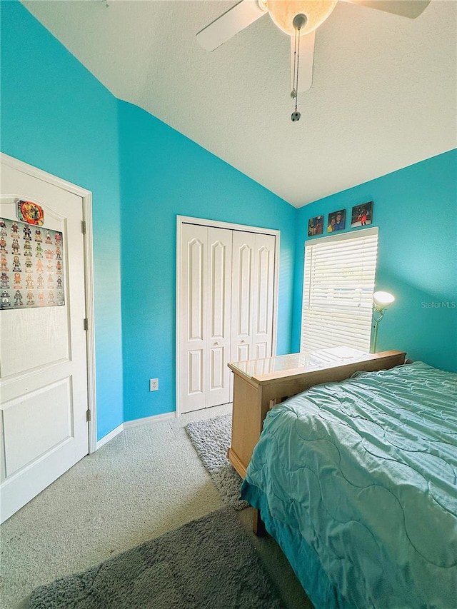 bedroom with ceiling fan, a textured ceiling, lofted ceiling, a closet, and carpet