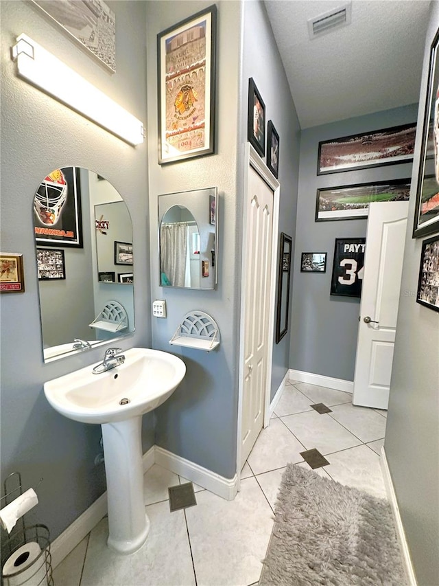 bathroom with tile patterned floors and a textured ceiling