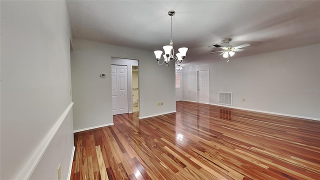 unfurnished room featuring ceiling fan with notable chandelier and hardwood / wood-style flooring