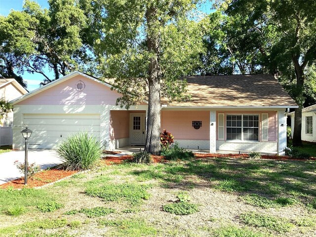 ranch-style house with a garage and a front lawn