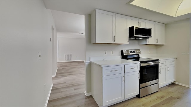 kitchen featuring visible vents, white cabinets, stainless steel appliances, and light countertops