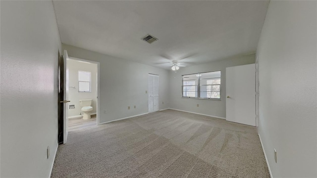 empty room featuring visible vents, carpet flooring, baseboards, and ceiling fan