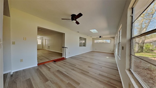 empty room with a ceiling fan, wood finished floors, and baseboards