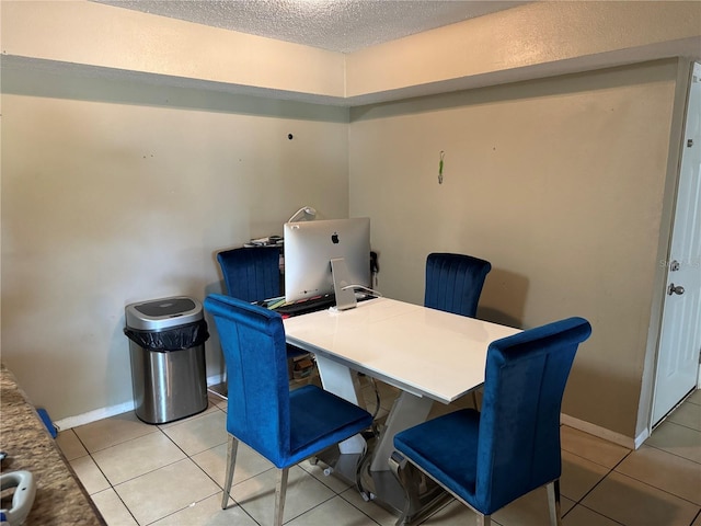 tiled dining area with a textured ceiling