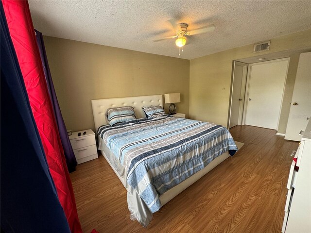 bedroom featuring a textured ceiling, ceiling fan, and hardwood / wood-style floors