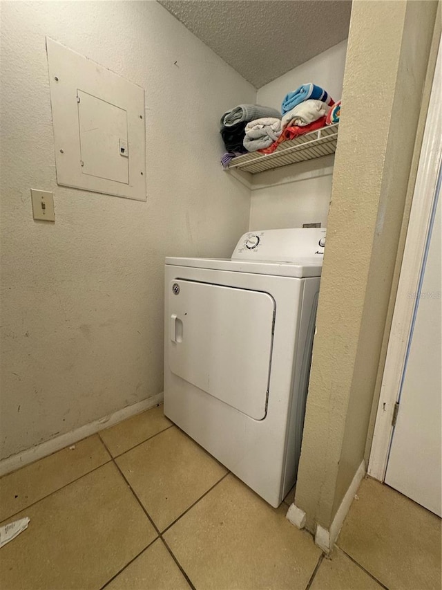 laundry room featuring light tile flooring, a textured ceiling, and washer / clothes dryer