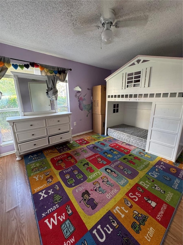 unfurnished bedroom with ceiling fan, a textured ceiling, and hardwood / wood-style flooring