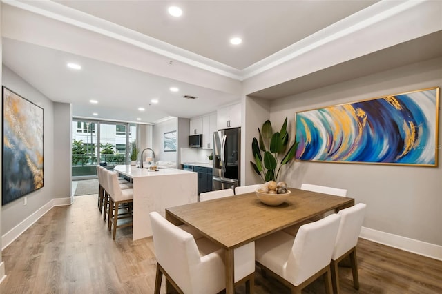 dining area with sink and light hardwood / wood-style floors