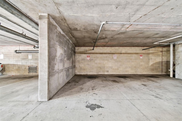 parking garage with visible vents and concrete block wall