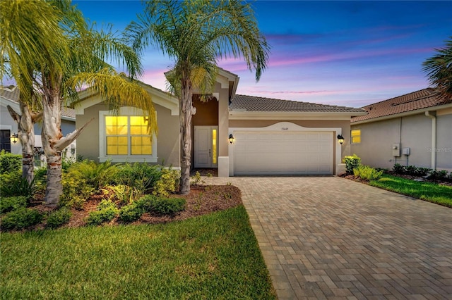 mediterranean / spanish house with a garage and a lawn