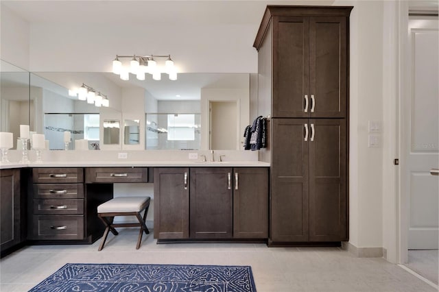 bathroom featuring tile patterned flooring, vanity, and a shower with door