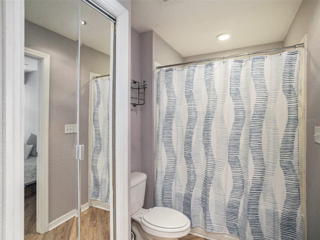 bathroom featuring a shower with curtain, hardwood / wood-style floors, and toilet