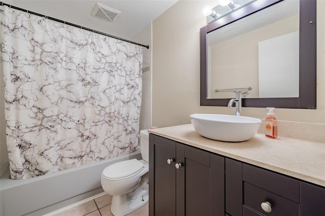 full bathroom with a textured ceiling, toilet, vanity, shower / tub combo with curtain, and tile patterned floors