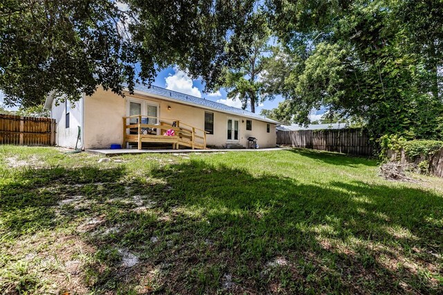 back of house with a yard and a deck