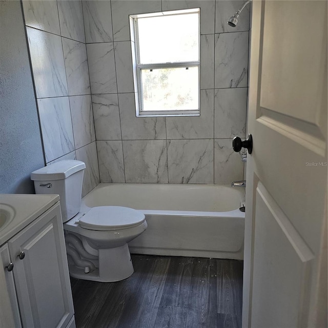 full bathroom featuring hardwood / wood-style floors, vanity, toilet, and tiled shower / bath combo