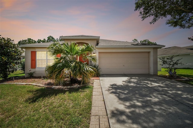 single story home featuring a garage and a lawn