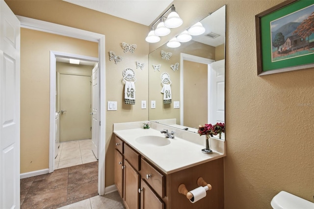 bathroom with vanity, tile patterned flooring, and toilet