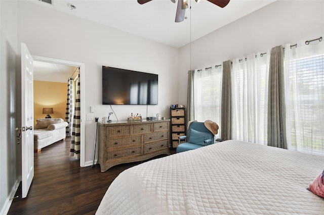 bedroom featuring ceiling fan, multiple windows, and dark hardwood / wood-style flooring