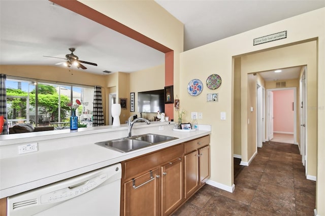 kitchen featuring dark tile patterned floors, white dishwasher, sink, lofted ceiling, and ceiling fan