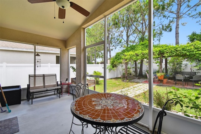 sunroom featuring ceiling fan and vaulted ceiling