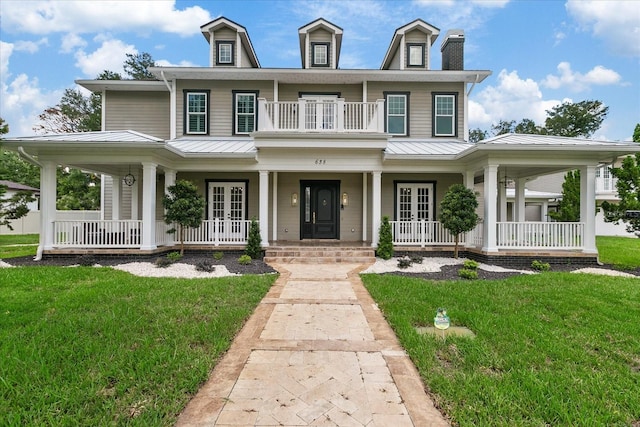 638 Limona Woods Dr, Brandon, FL 33510 - view of front facade featuring covered porch, metal roof, and a front lawn