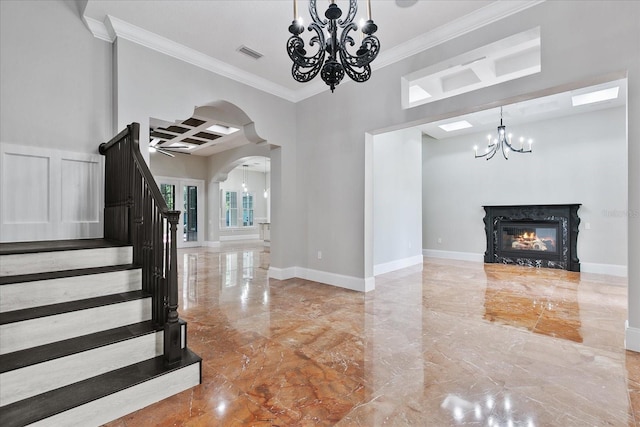 unfurnished living room featuring tile flooring, ornamental molding, a high end fireplace, and an inviting chandelier