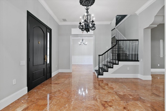 entrance foyer featuring tile floors, ornamental molding, and a chandelier