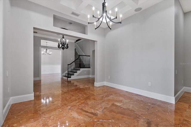 spare room with a notable chandelier, tile flooring, coffered ceiling, and beam ceiling