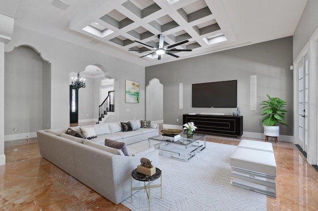 living room featuring beamed ceiling, a high ceiling, coffered ceiling, and ceiling fan with notable chandelier