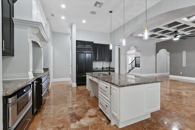 kitchen with ceiling fan, beam ceiling, a large island, coffered ceiling, and white cabinets