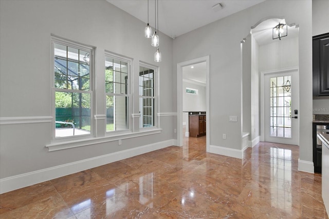 unfurnished dining area featuring tile floors and a high ceiling