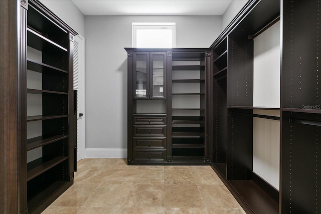 walk in closet featuring light tile floors