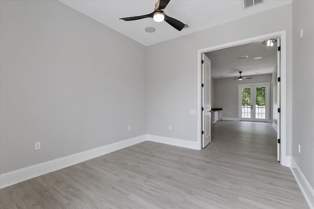 empty room featuring ceiling fan, light hardwood / wood-style flooring, and french doors