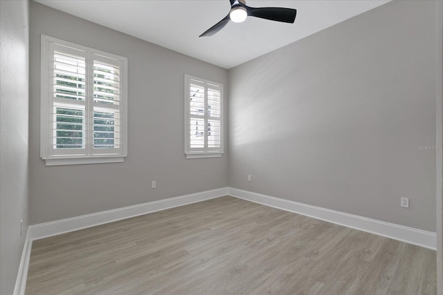 empty room with a healthy amount of sunlight, ceiling fan, and light hardwood / wood-style floors